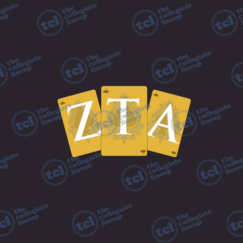 A graphic design for Zeta Tau Alpha featuring three gold playing cards with the letters Z, T, and A in white, decorated with crowns and ornate filigree patterns on a dark background.